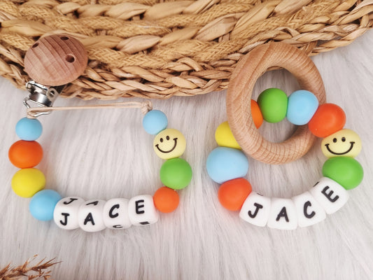 Bijtring met naam - Smiley, babyblauw, oranje, geel, groen