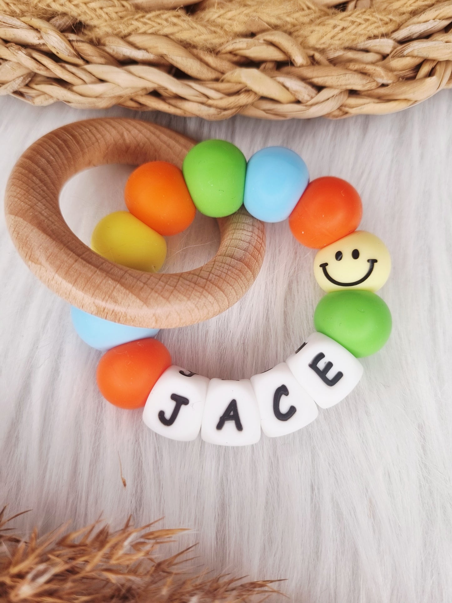 Bijtring met naam - Smiley, babyblauw, oranje, geel, groen