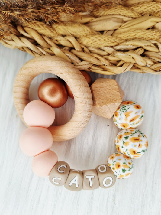 Bijtring met naam bloem oranje, metallic brons, light pink 