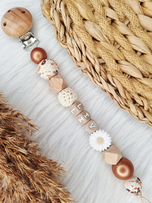 Speenkoord met naam jouw eigen ontwerp 
Diasy wit, bloem bruin, metallic brons