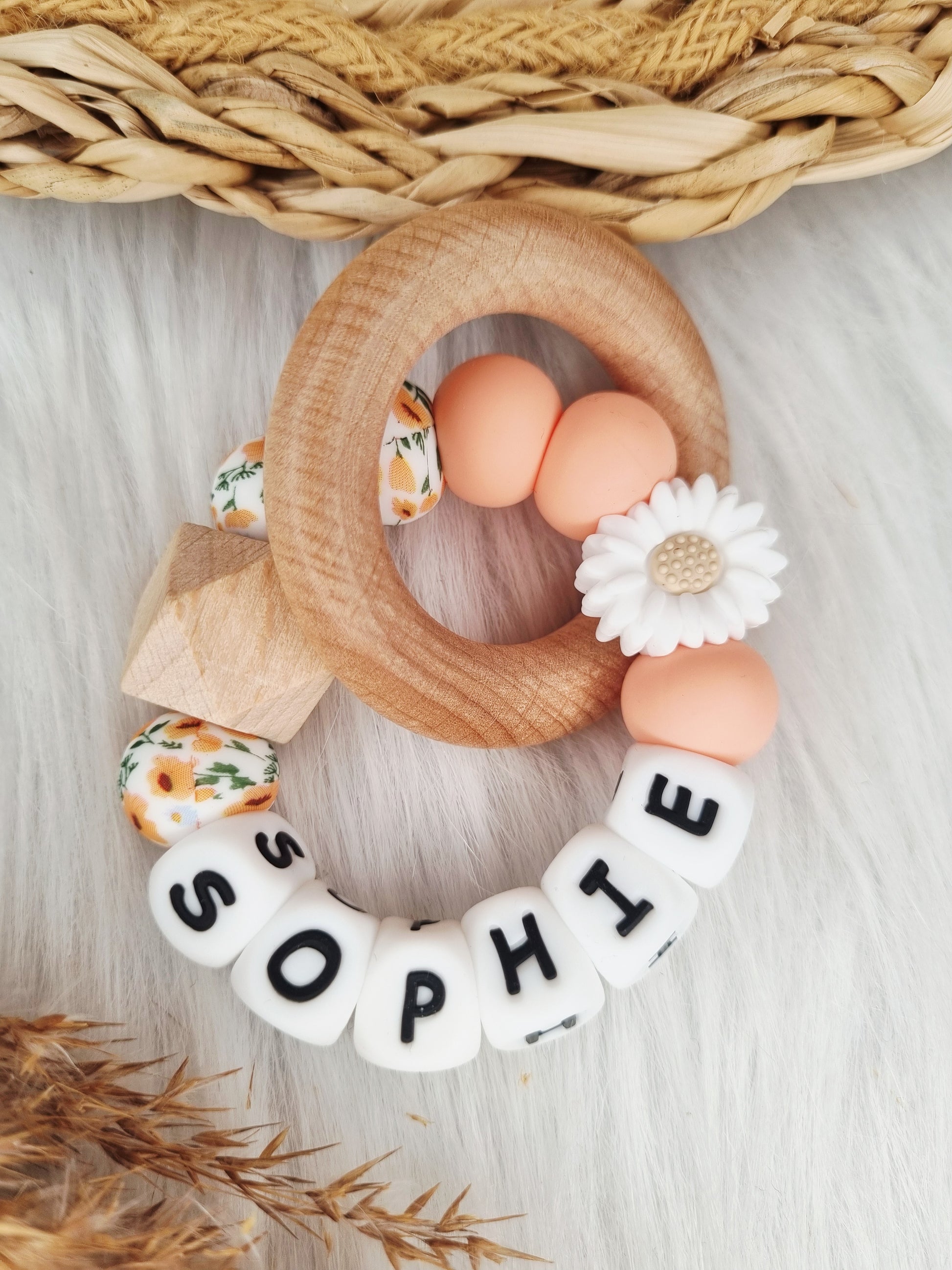Bijtring met naam en figuurtje 
Daisy wit, peach, bloem oranje