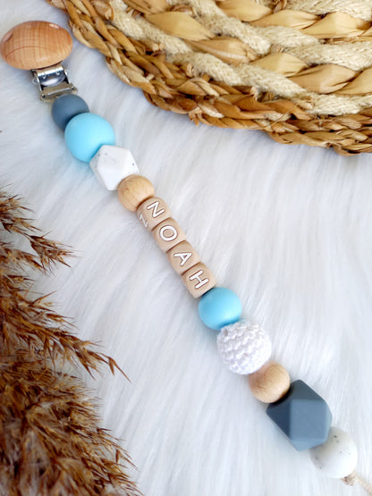Met deze hippe speenkoord raak je je speen nooit meer kwijt. Hij is makkelijk te bevestigen op de kleding van je kleintje. Deze verantwoorde speenkoord is niet alleen handig maar ook heel hip. Speenketting, babyaccessoires, nursery, happy by lies, tuttenkoord, siliconen kralen. speenkoord met naam noah blauw