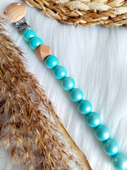Met deze hippe speenkoord raak je je speen nooit meer kwijt. Hij is makkelijk te bevestigen op de kleding van je kleintje. Deze verantwoorde speenkoord is niet alleen handig maar ook heel hip. Speenketting, babyaccessoires, nursery, happy by lies, tuttenkoord, siliconen kralen. speenkoord met naam uni glossy turquoise