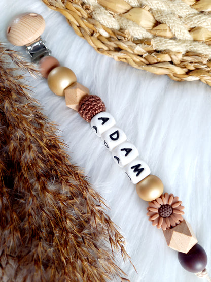 Met deze hippe speenkoord raak je je speen nooit meer kwijt. Hij is makkelijk te bevestigen op de kleding van je kleintje. Deze verantwoorde speenkoord is niet alleen handig maar ook heel hip. Speenketting, babyaccessoires, nursery, happy by lies, tuttenkoord, siliconen kralen. speenkoord met naam daisy bruin
